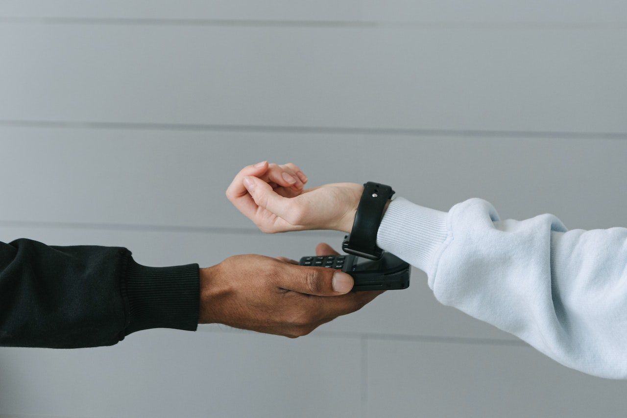 Two hands interacting with a black smartwatch