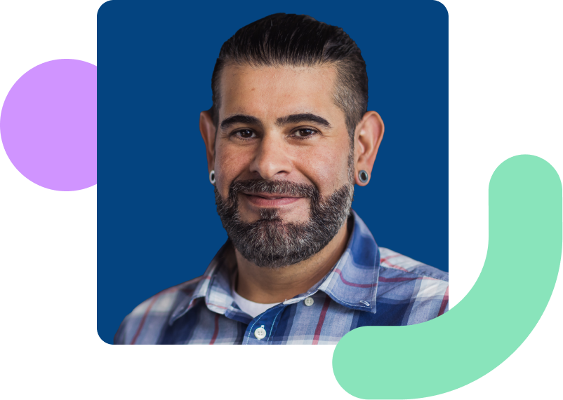 Image shows a man smiling with a dark blue background